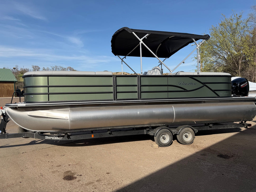 Pontoon boat on a trailer with a clear sky background