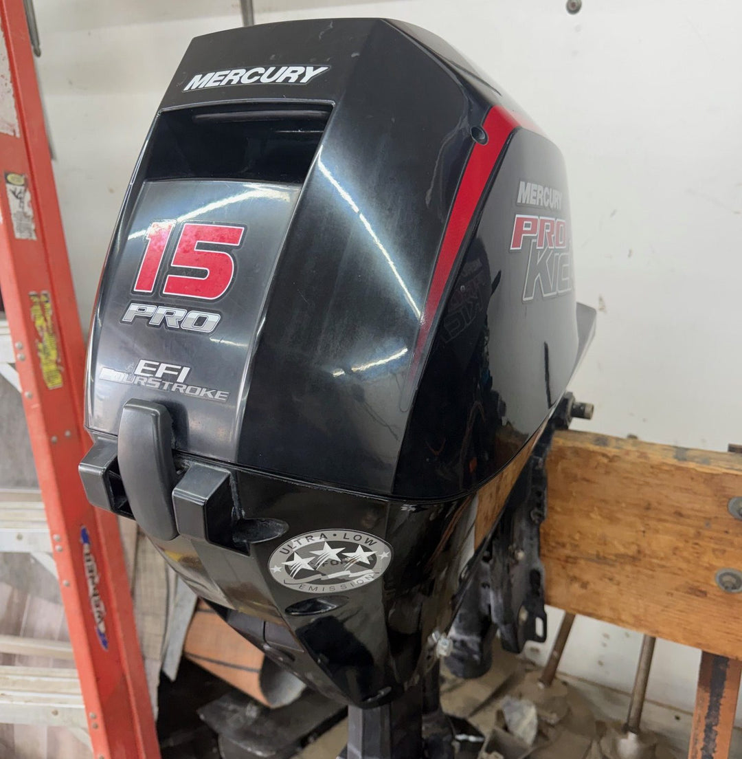 15 horsepower Mercury outboard motor on a stand in a workshop setting