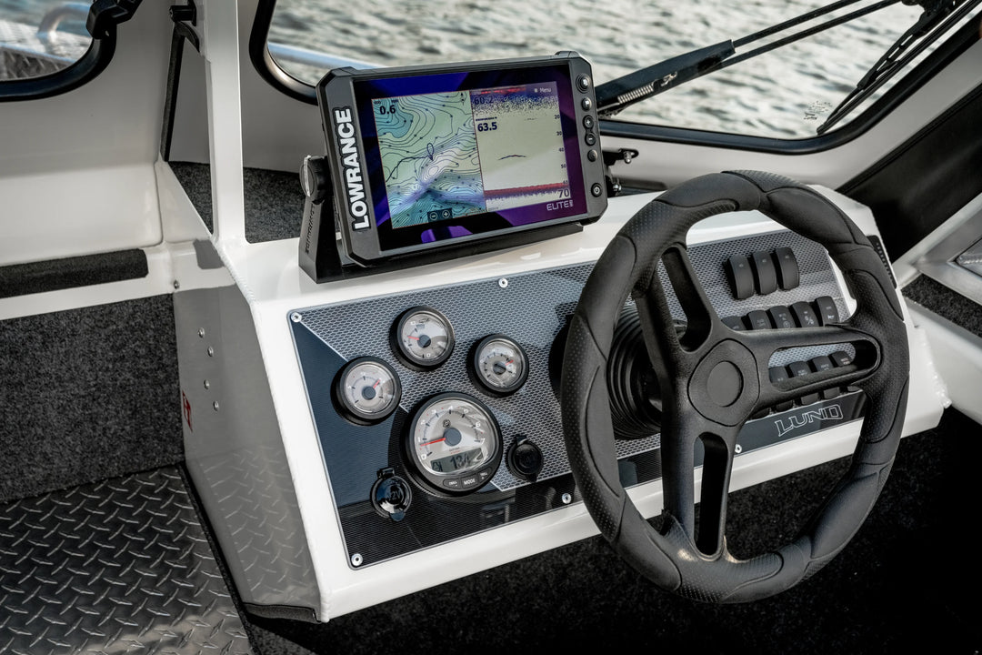 Boat dashboard with steering wheel and Lowrance navigation device.