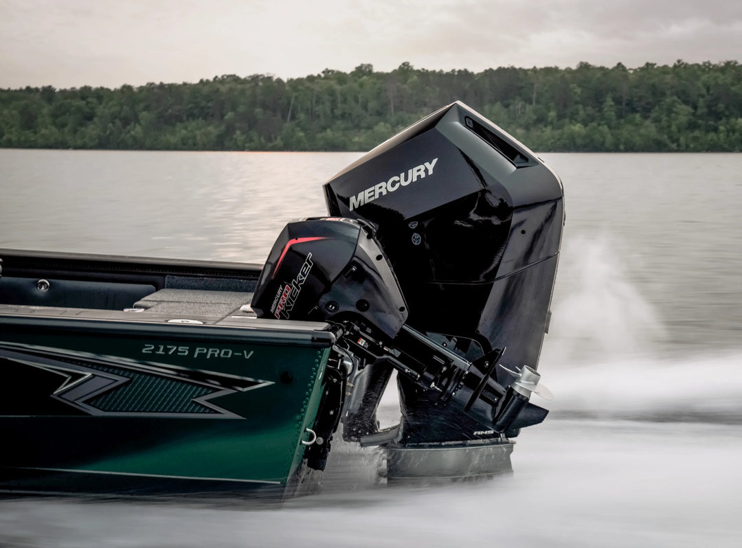 Mercury outboard motor on a boat moving through water with trees in the background