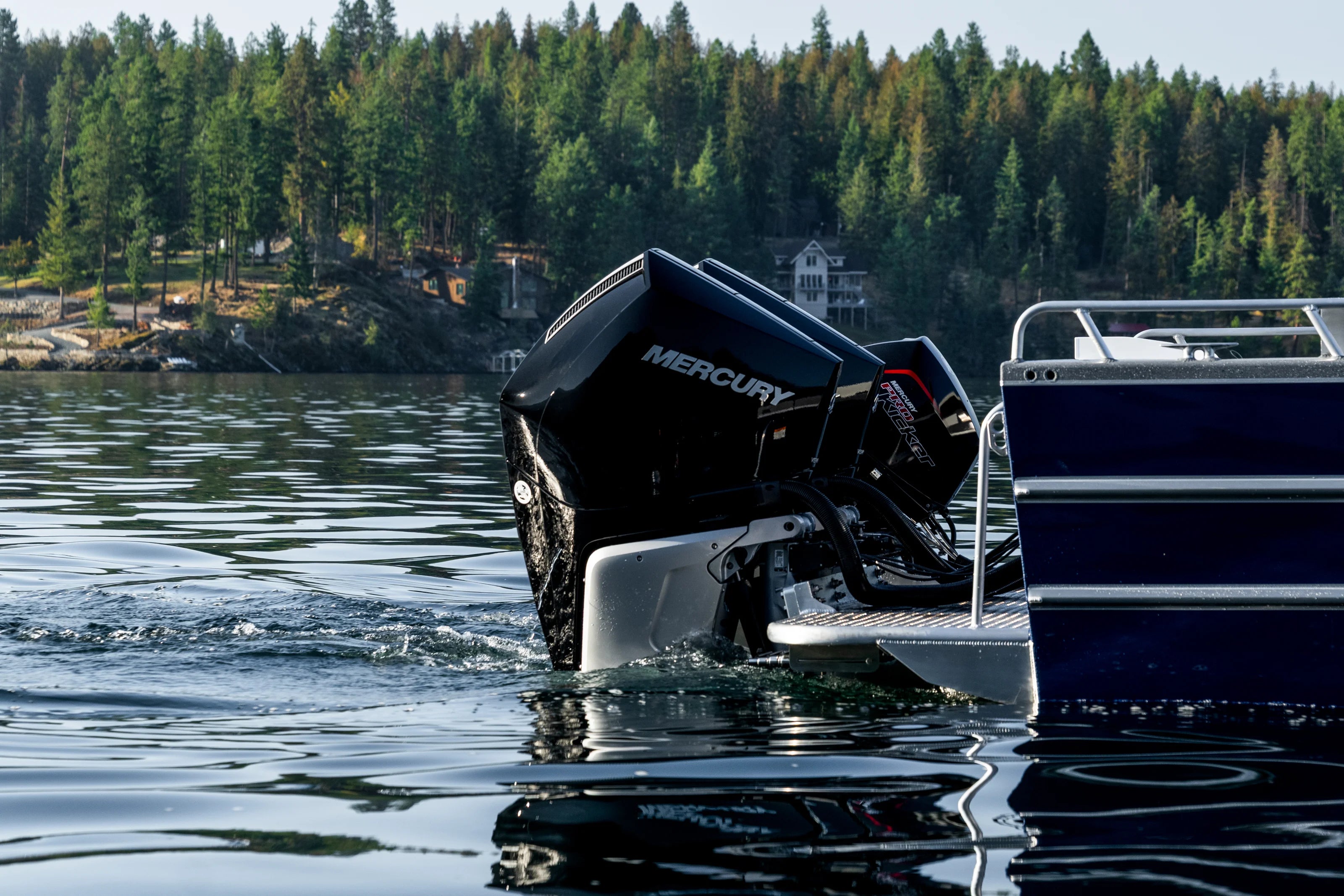 Boat with Mercury outboard motor on a lake surrounded by trees
